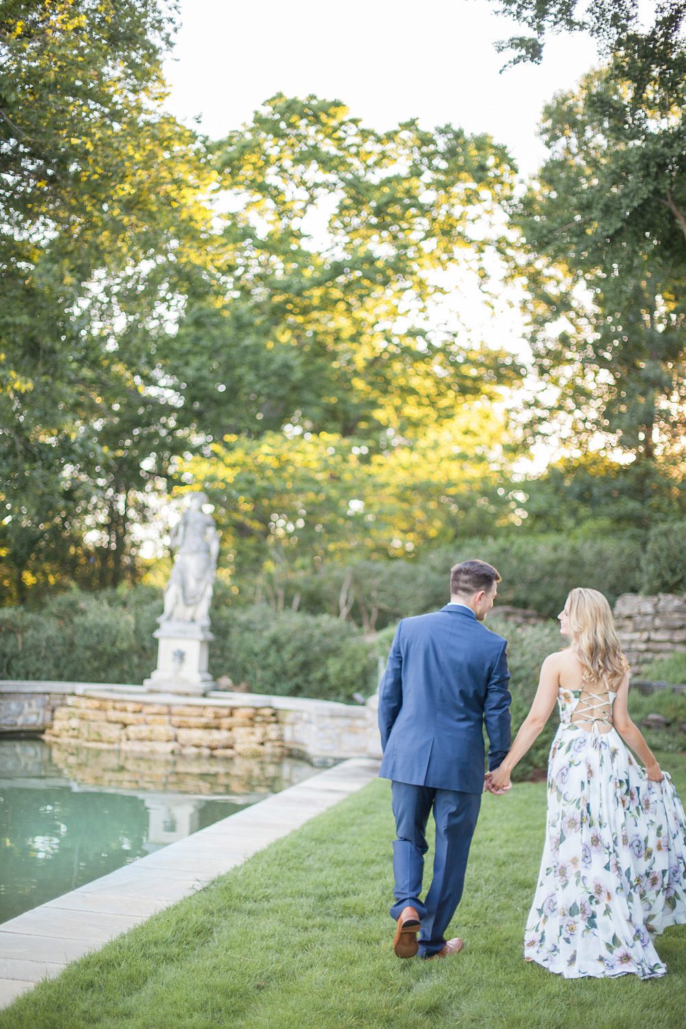 couple walking next to reflection pool for engagement session at cheekwood estate and gardens photo by krista lee photography