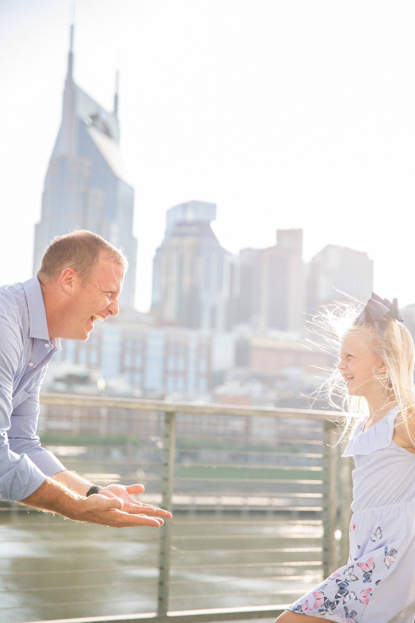 dad plays with daughter for photo session on pedestrian bridge nashville