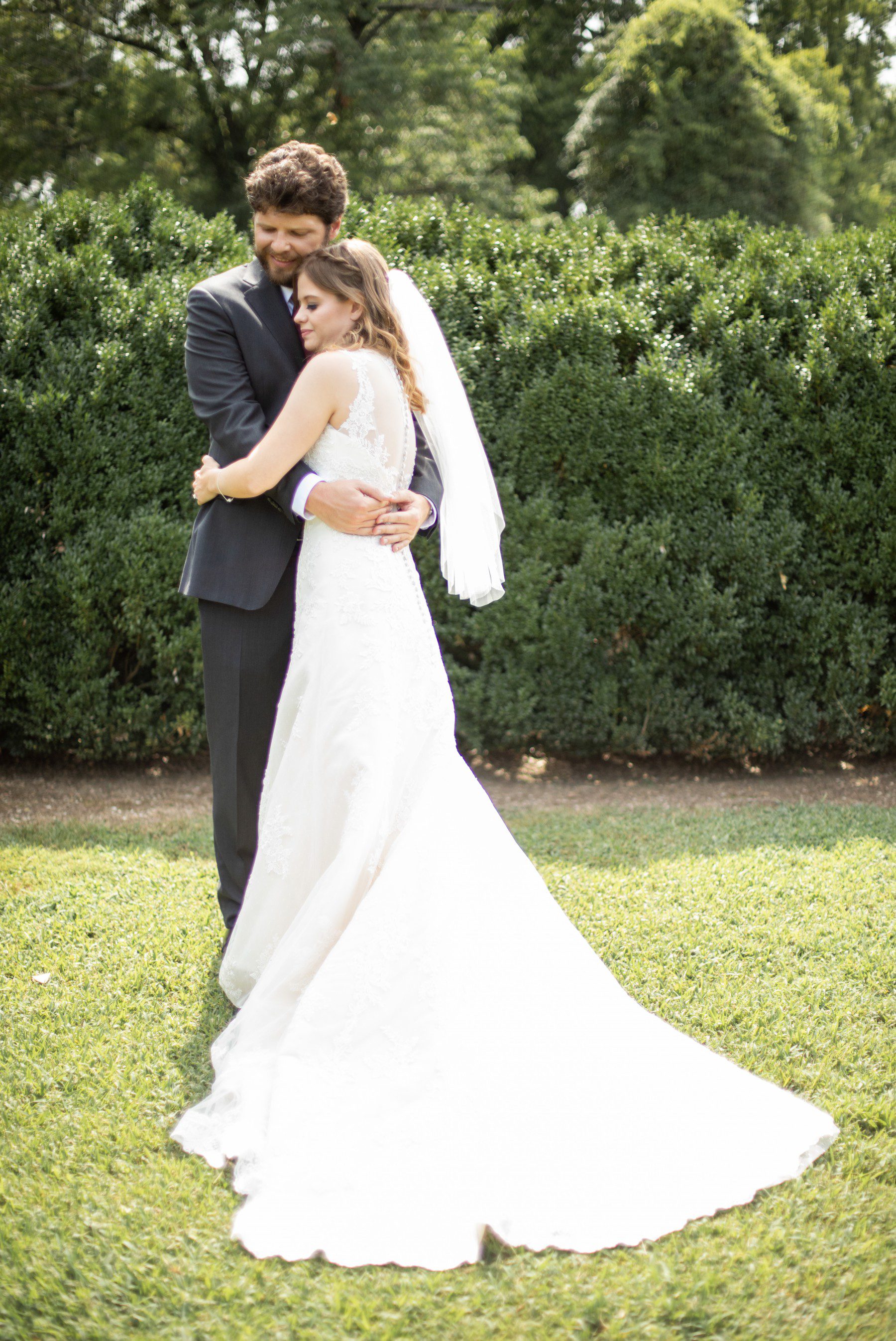 Bride and groom hug in boxwood gardens, two rivers mansion wedding 