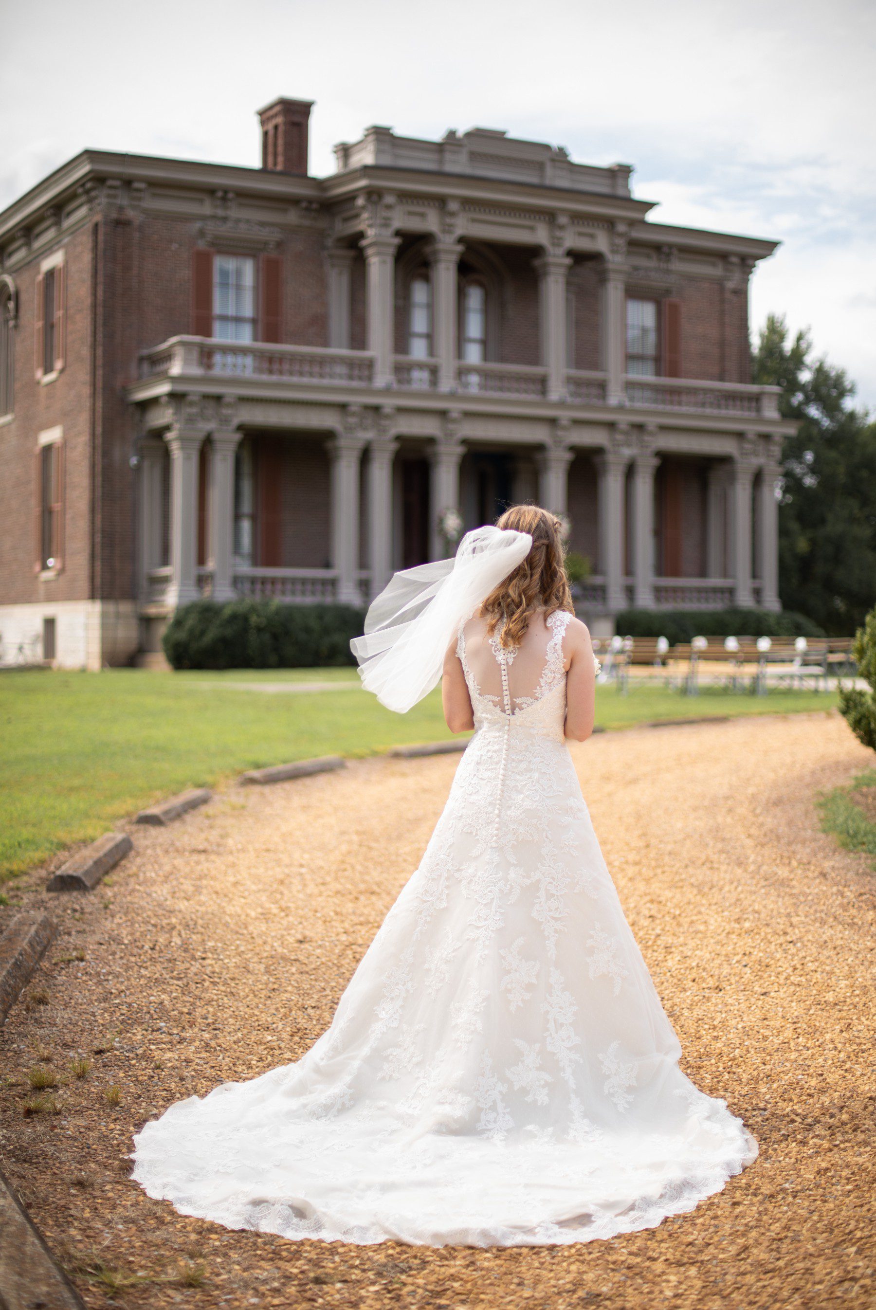 Bride waits in front of house at Two Rivers Mansion