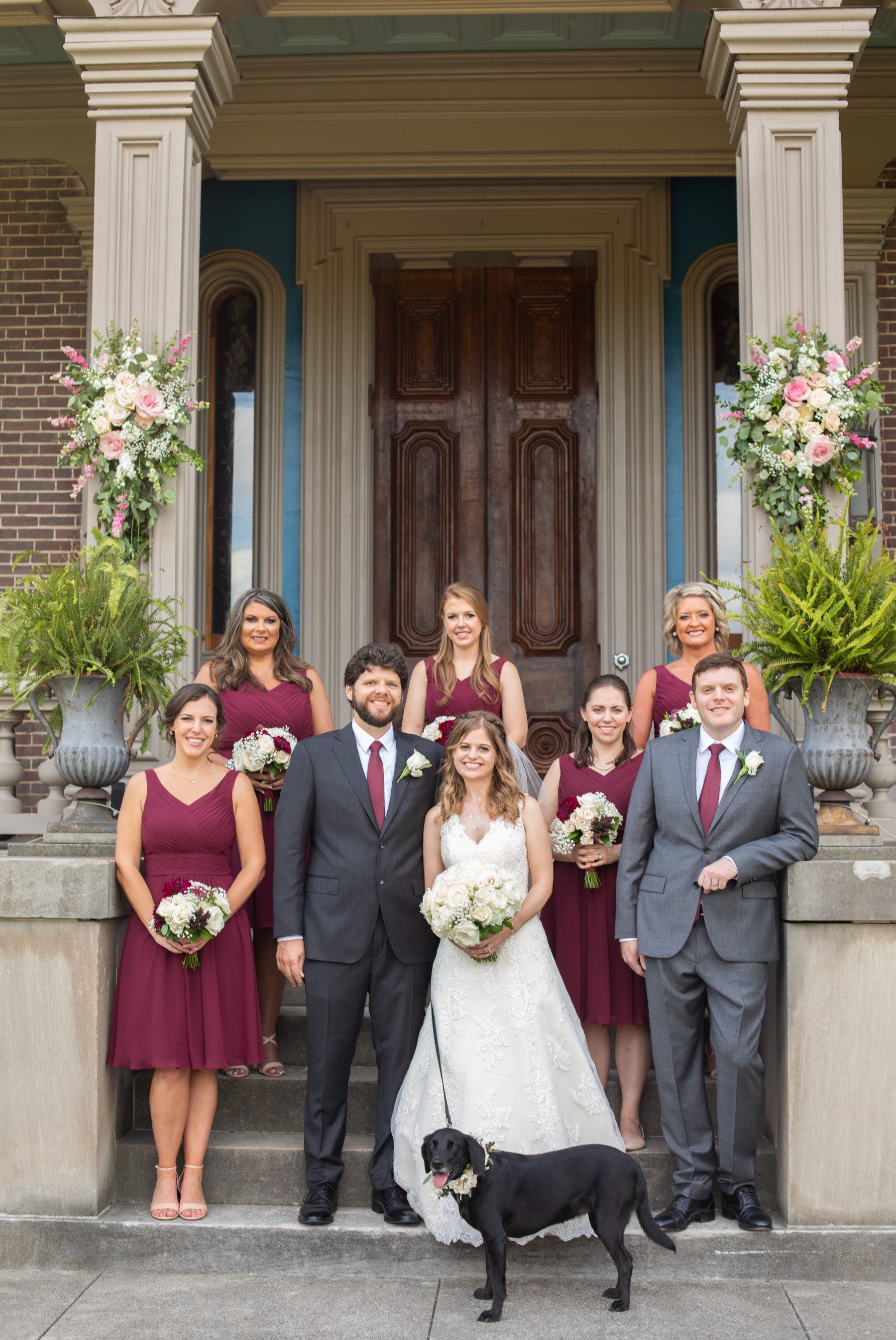 bridal party on steps with dog at Two Rivers Mansion