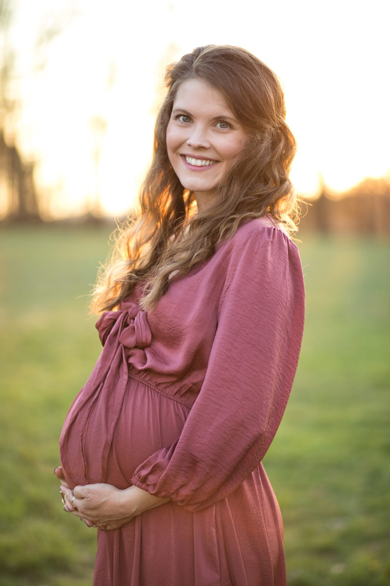 Sunset maternity portrait photo in a field 