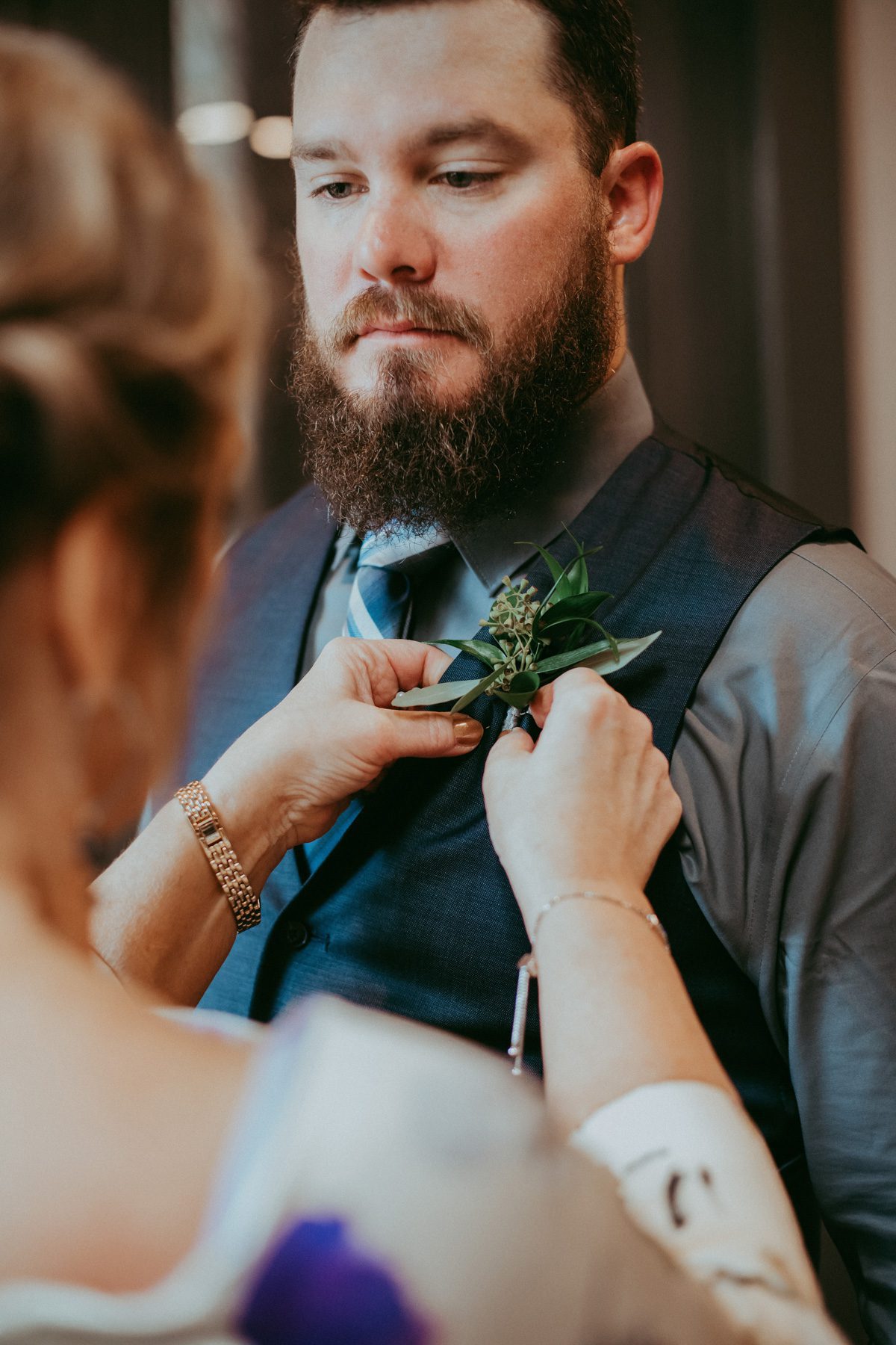 Pinning Boutonniere on wedding day 