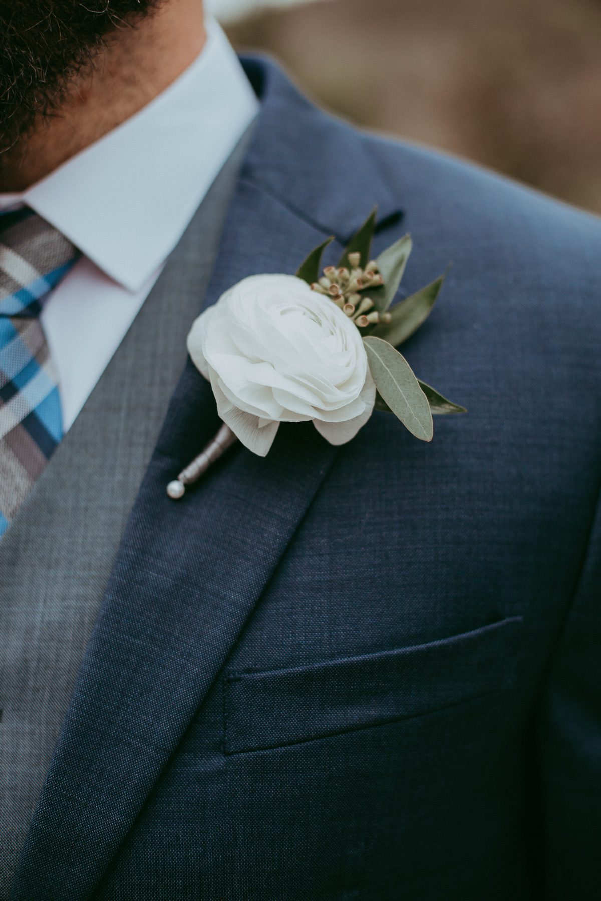 White ranunculus and seeded eucalyptus boutonniere 