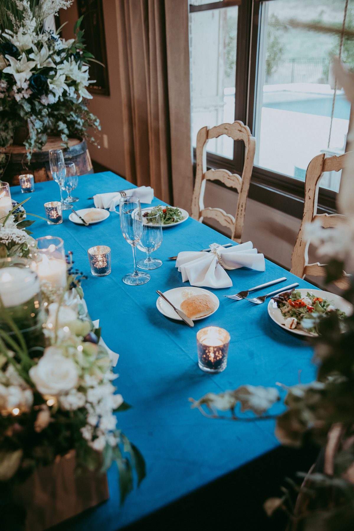 Sweetheart table at wedding recpetion with white flowers and blue linens 
