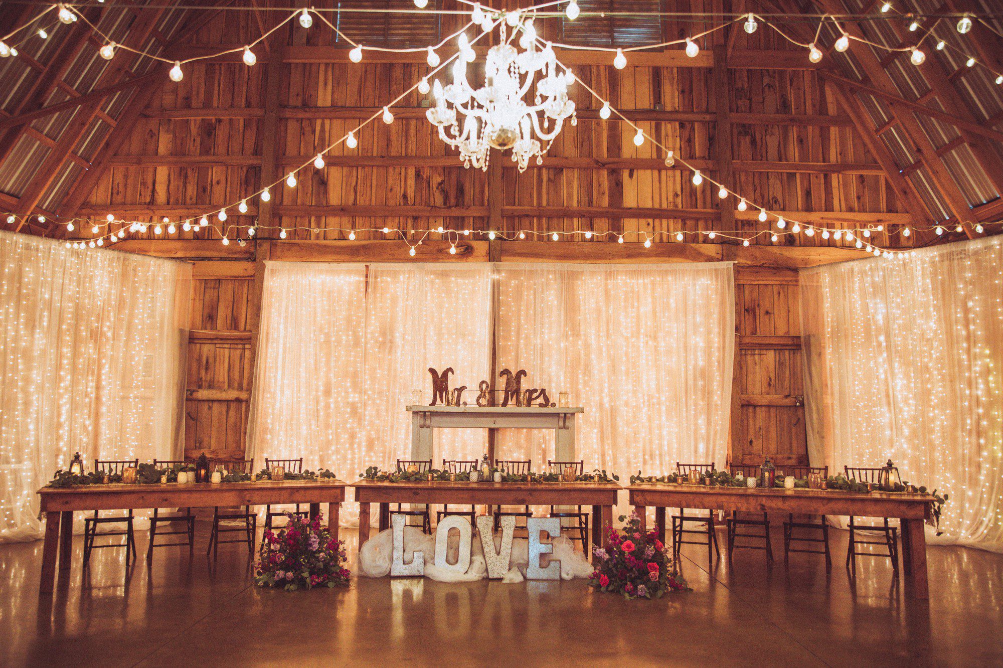 Rustic barn wedding decor with glam chandelier 