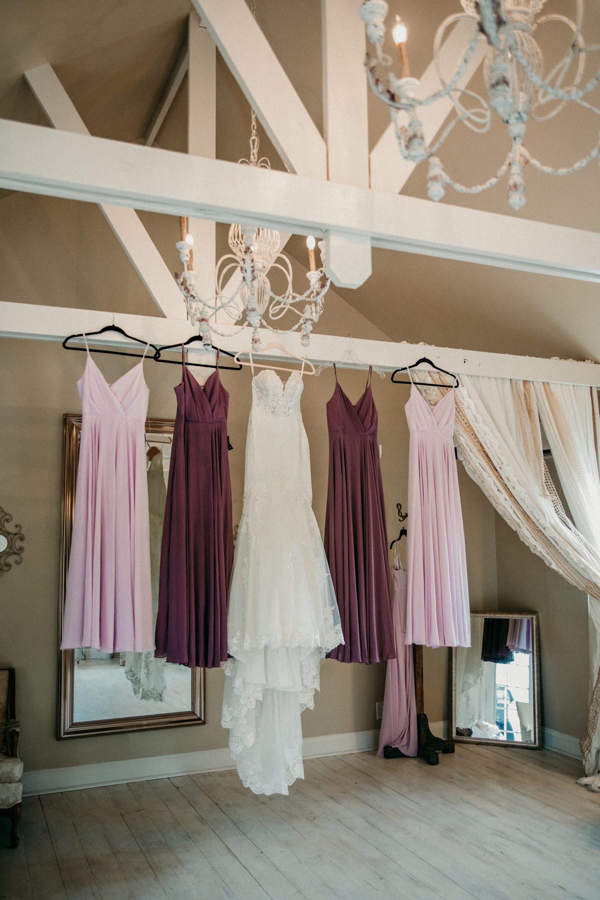spring lilac and plum dresses hang in bridal suite before wedding ceremony at Front Porch Farms Charlotte TN