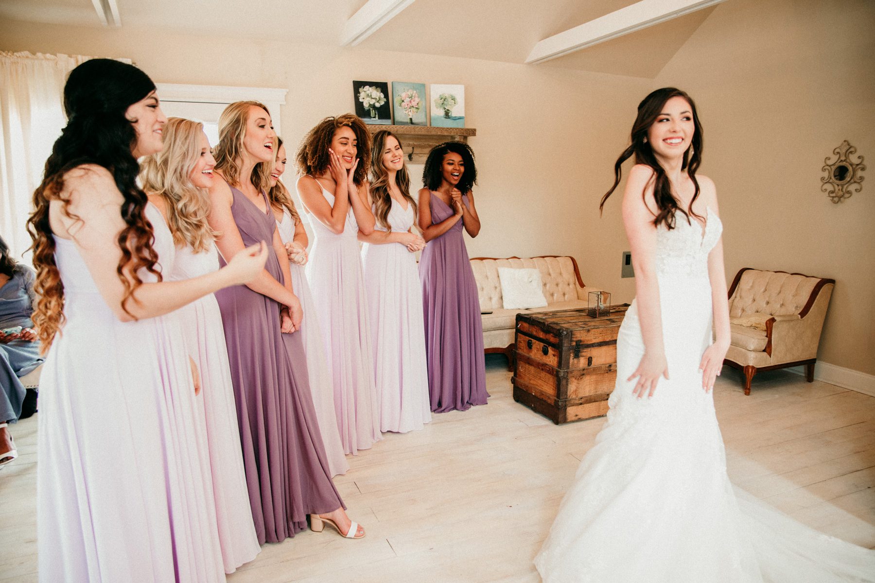 Bridesmaids react to bride in wedding dress 