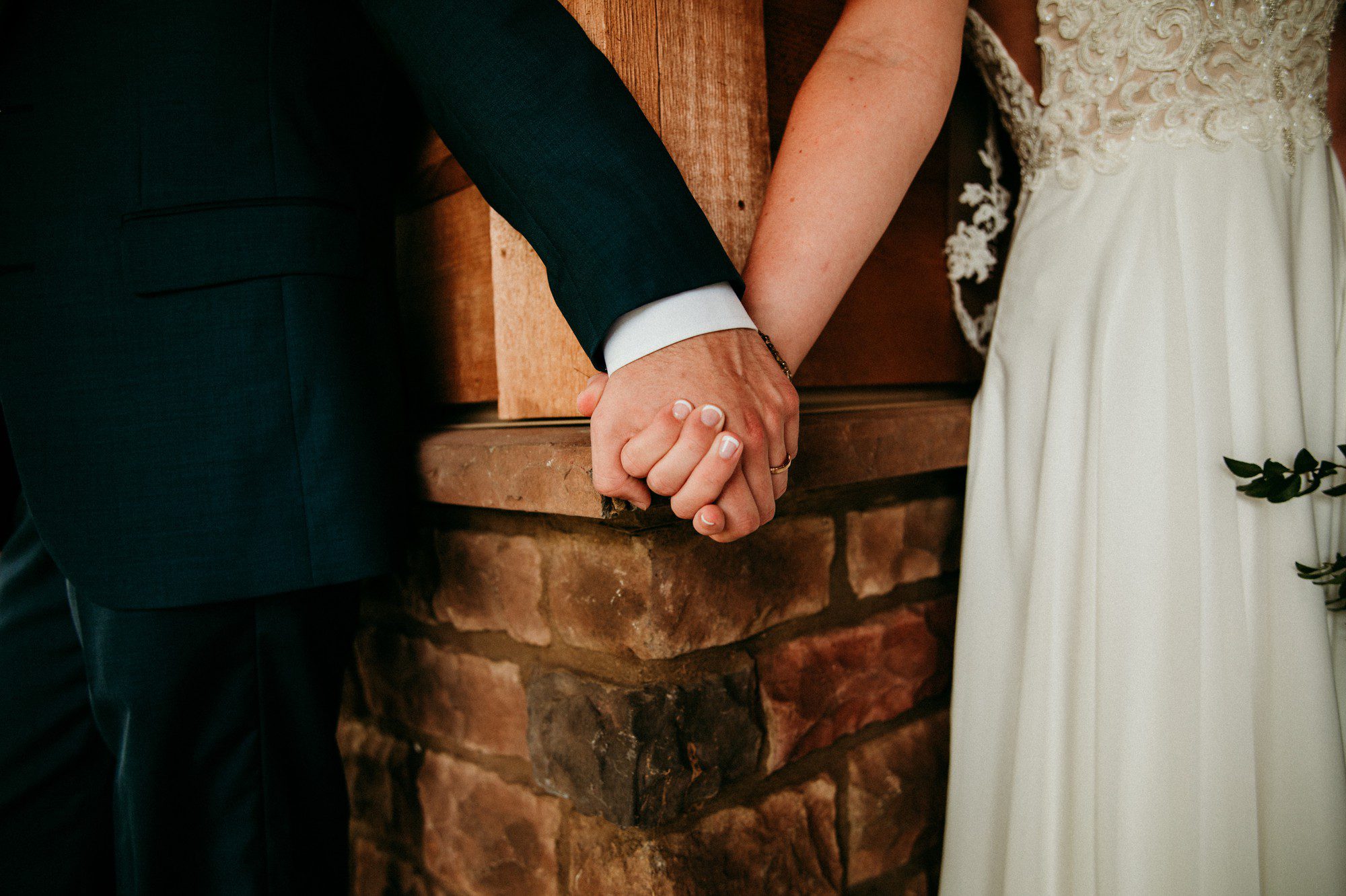 Bride and groom hold hands without seeing each other on wedding day 