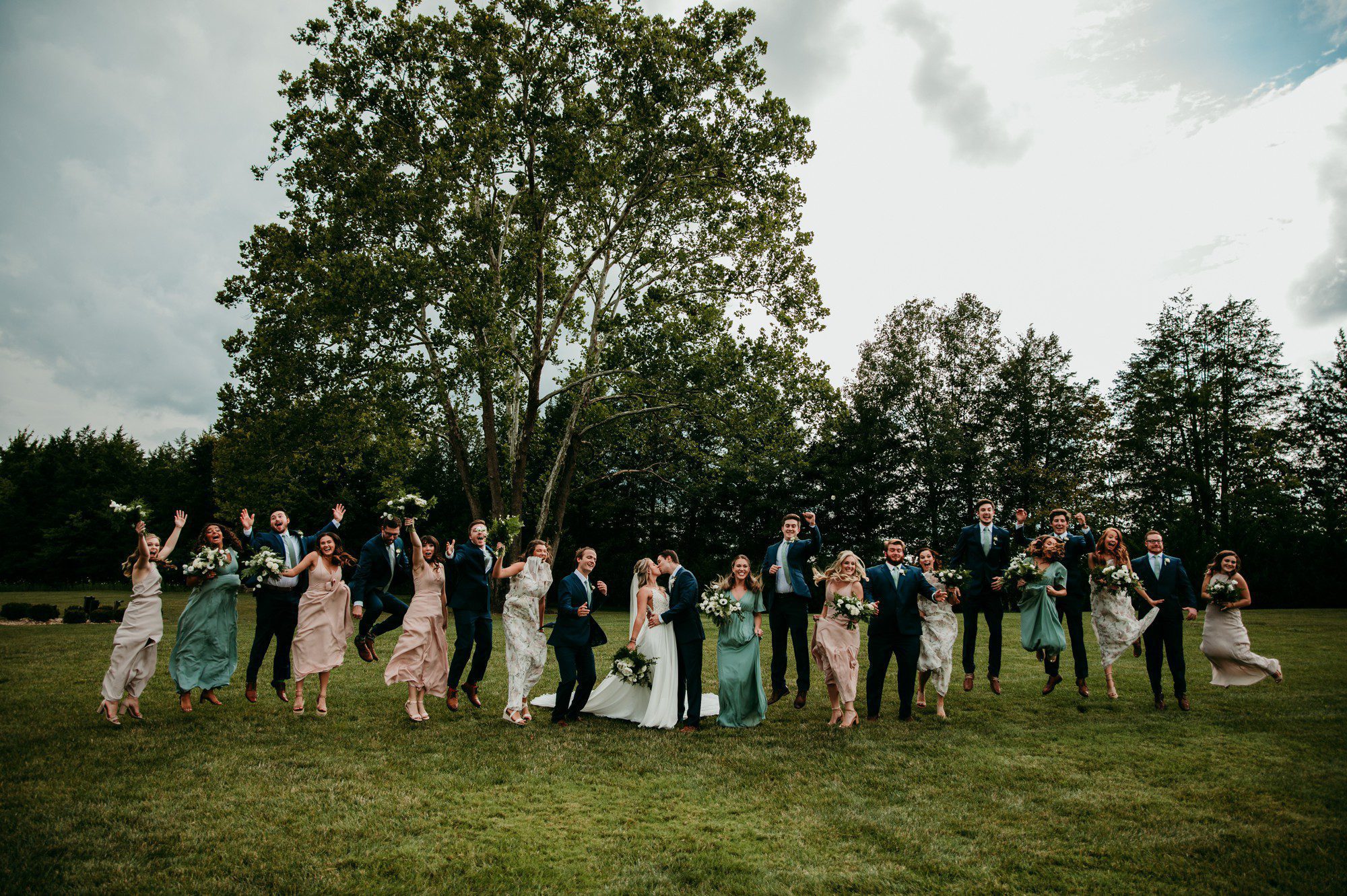 Large wedding party group jumping photo at The Barn at Sycamore Farms Arrington, TN
