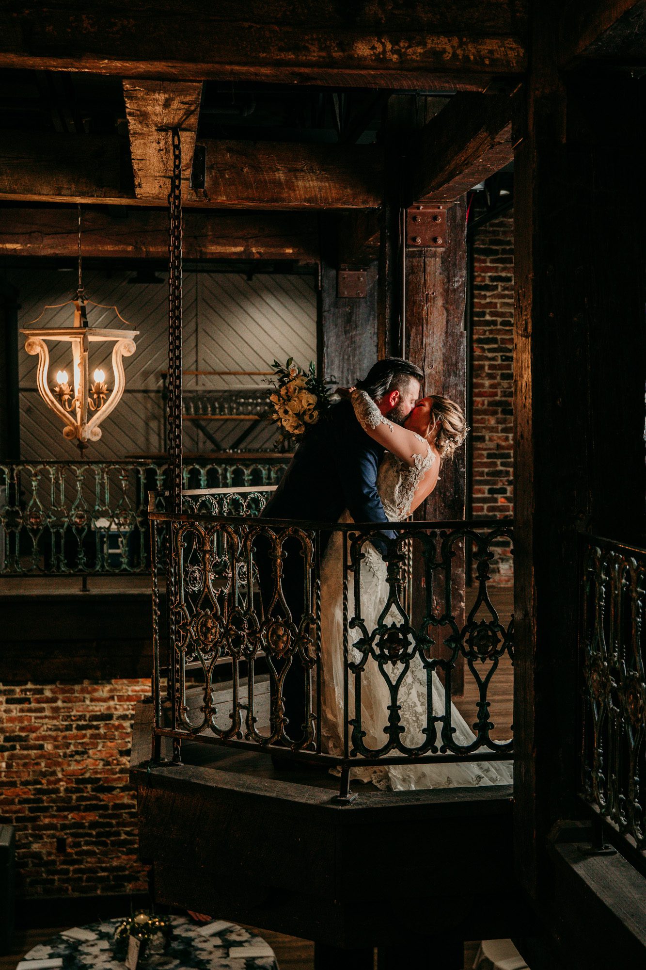 Bride and groom on balcony inside a vintage brick building old world charm at the Bedford event and wedding venue in Nashville TN. Photo by Krista Lee Photography